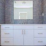Grey stone pattern tiled contemporary bathroom interior design with minimal natural wood furniture details dominate neutral colors. Interior design of a bathroom restroom interior design